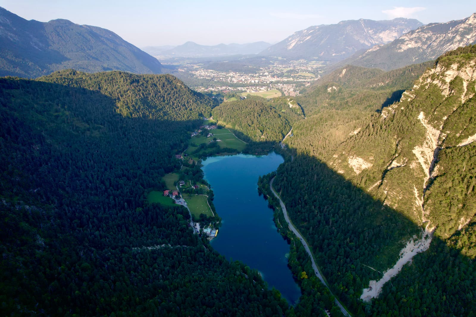 Luftbild des Thumsees im bewaldeten Bergtal bei Bad Reichenhall mit der Stadt im Hintergrund