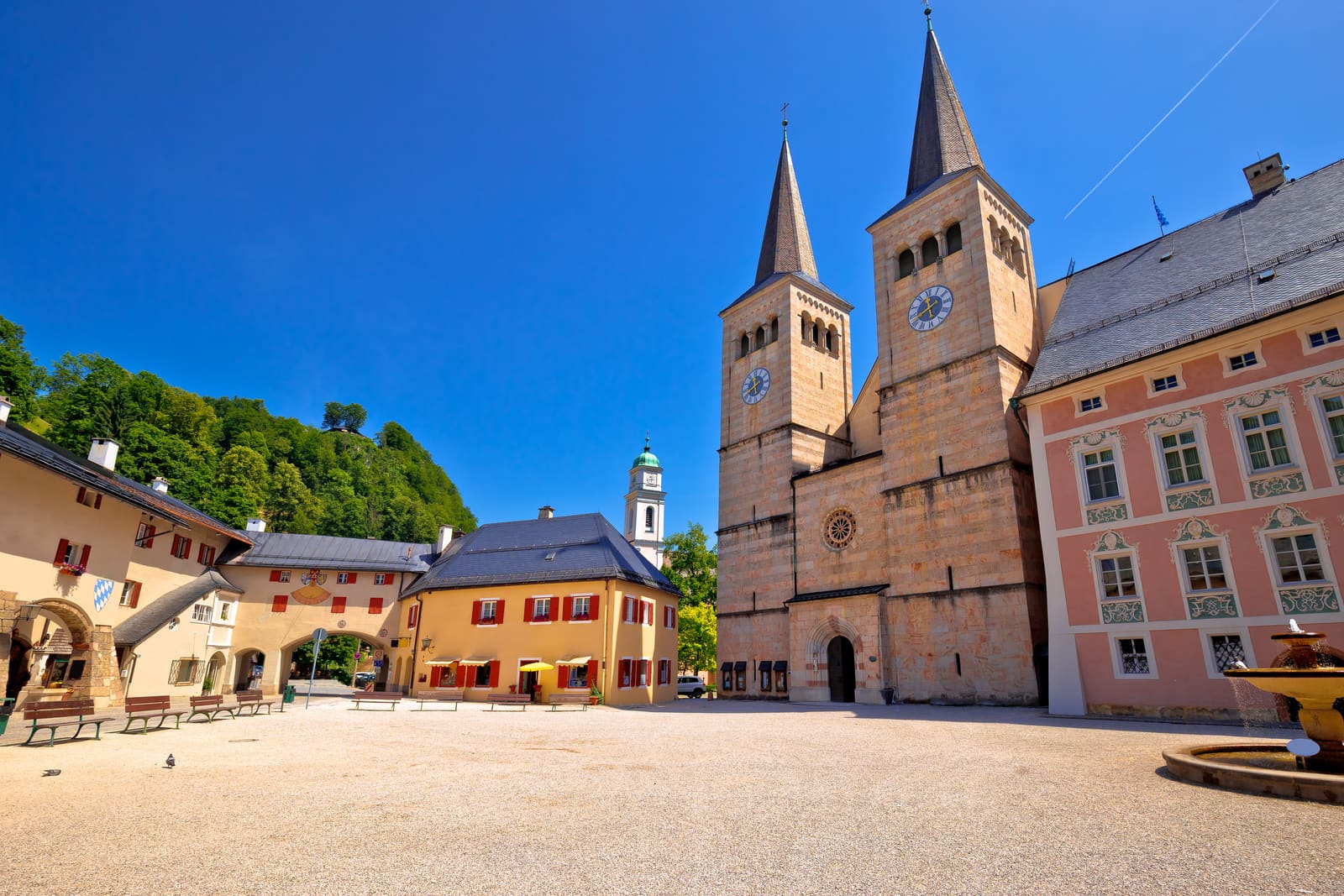 Schlossplatz in Berchtesgaden mit den Doppeltürmen der Stiftskirche, historischen Fassaden und Brunnen