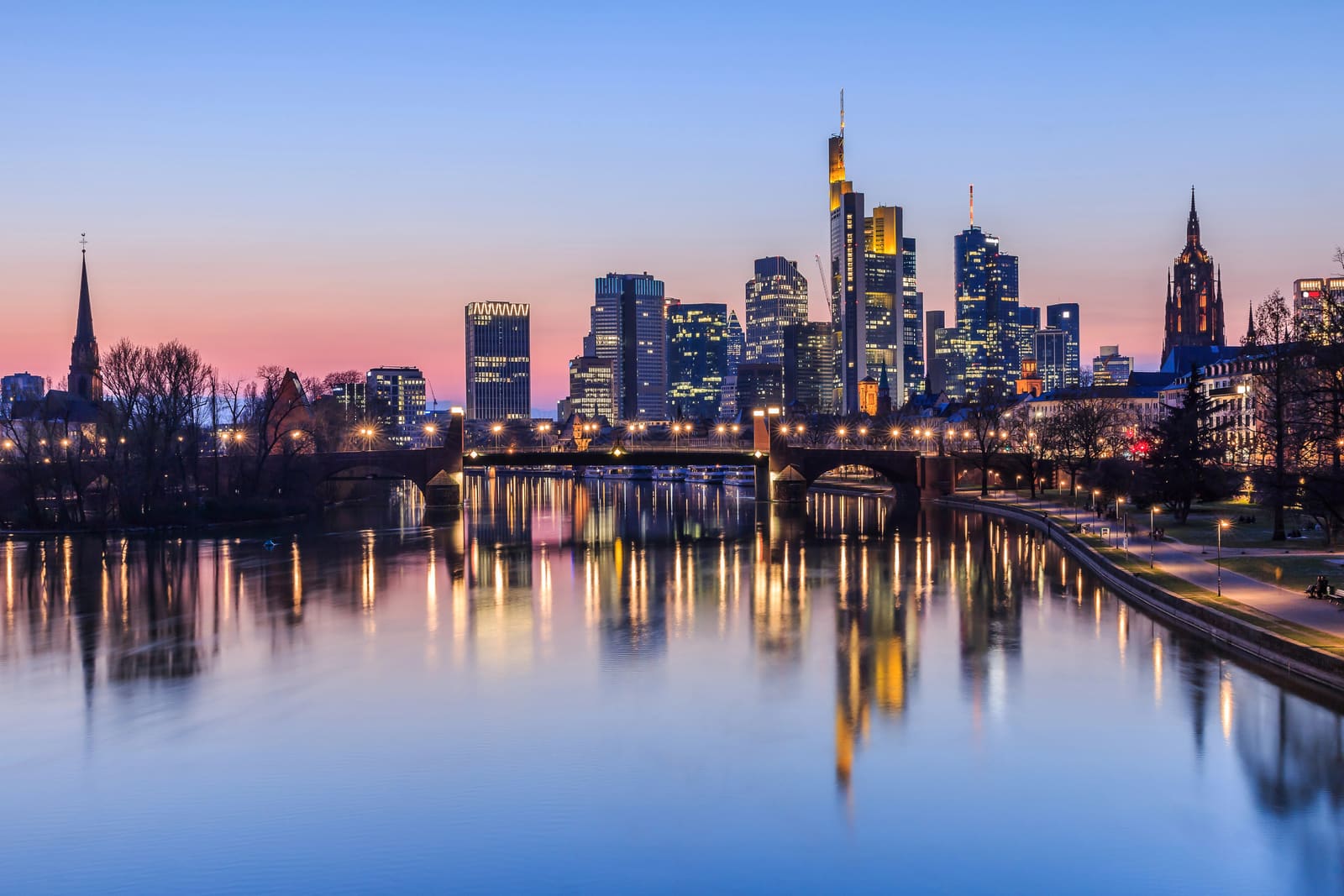 Beleuchtete Frankfurter Skyline mit Commerzbank Tower, Kaiserdom und Untermainbrücke, gespiegelt im Main zur blauen Stunde