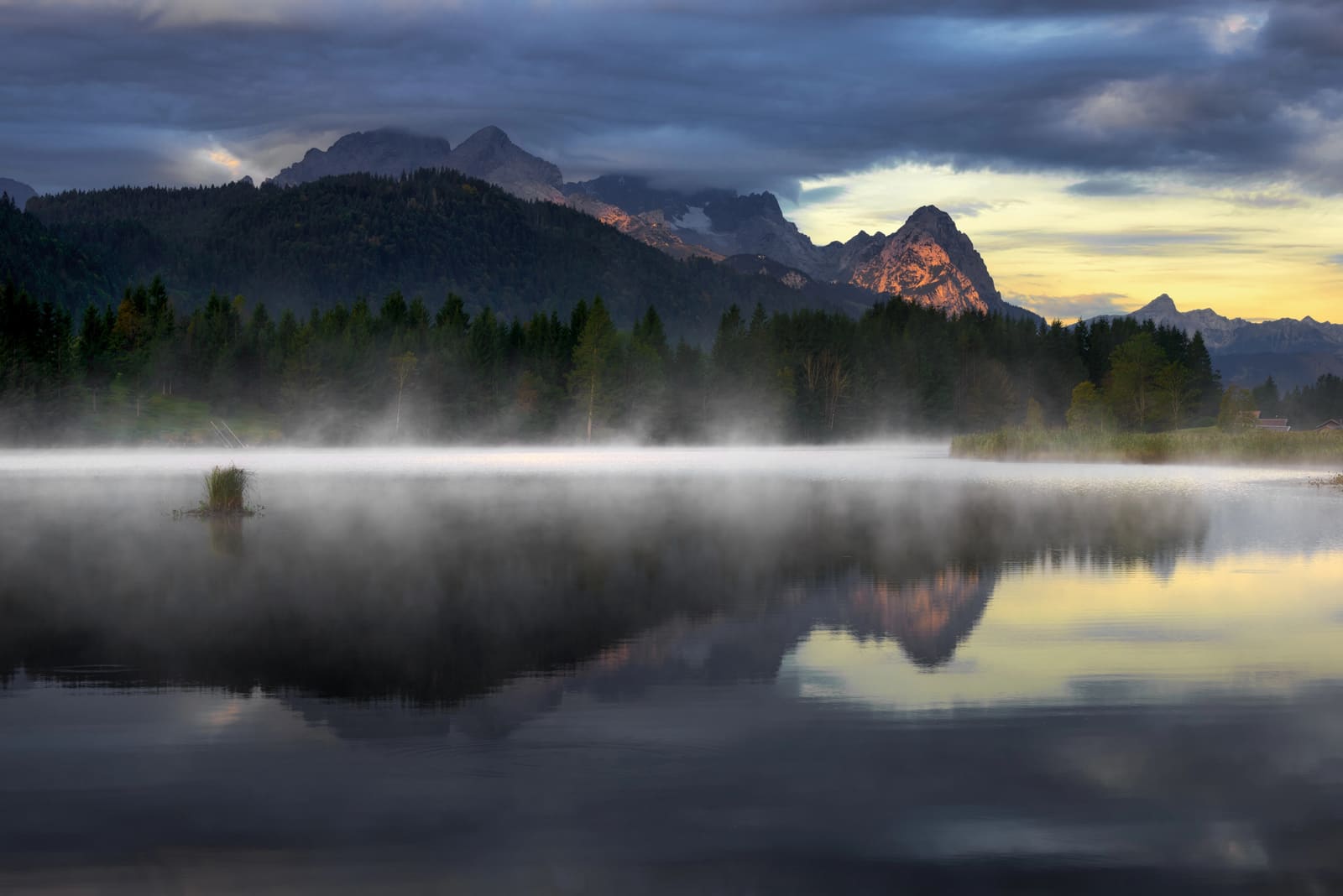 Morgennebel über dem Geroldsee mit Spiegelung des Wettersteingebirges im Wasser